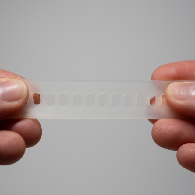 Hands stretching a translucent silicone wristband